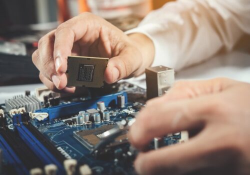 A pc technician repairs a pc on a table