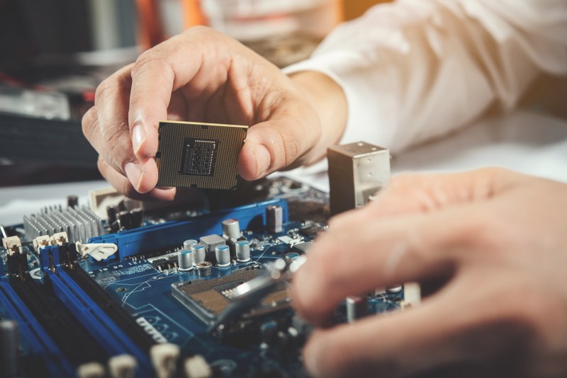 A pc technician repairs a pc on a table